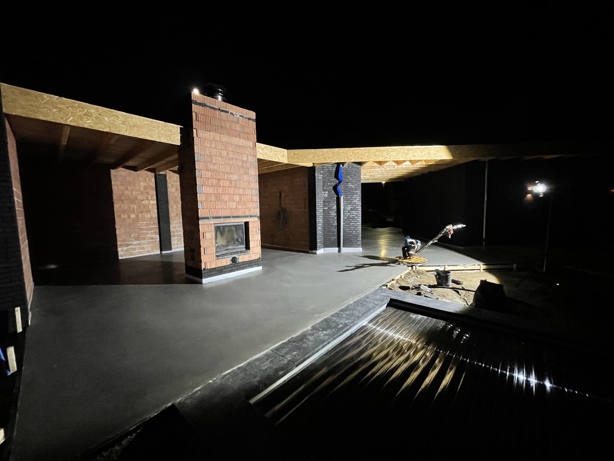 De vlindermachine op een verse betonvloer, bij avond onder bouwlampen