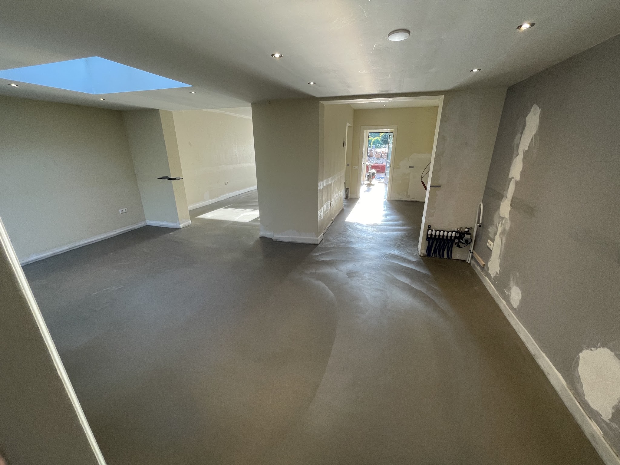 Strakke grijze betonvloer door een verbouwd interieur