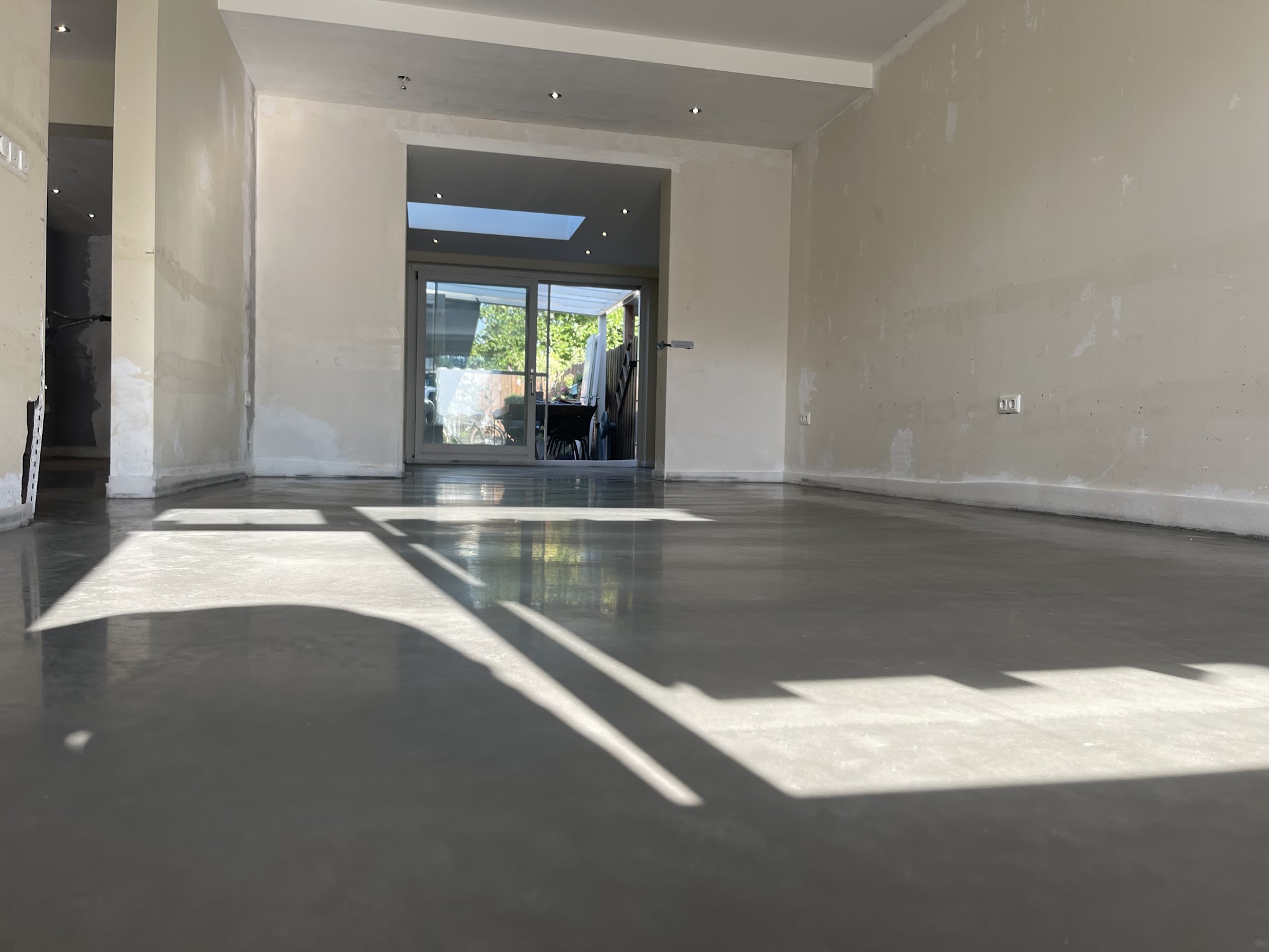 Gevlinderde betonvloer binnen, met zonlicht erover